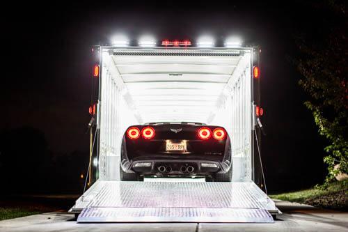 A Transtar trailer with a sports car in the back