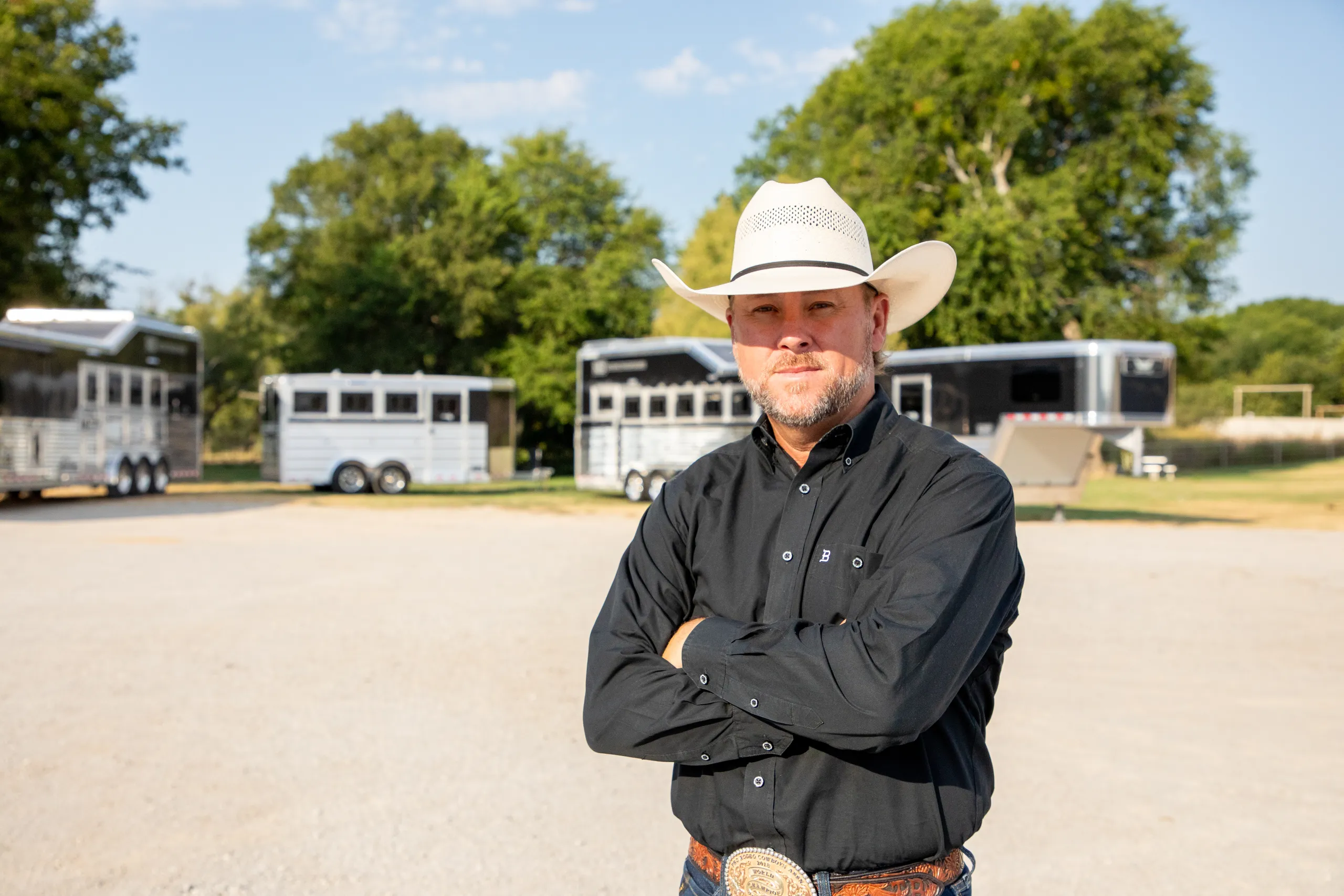 Trevor Brazile proudly standing before a trailer